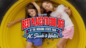 Graphic that says “Best Places to Cool Off at the Indiana State Fair: AC, Shade & Water” over a photo of two children inside a large yellow tractor tire.